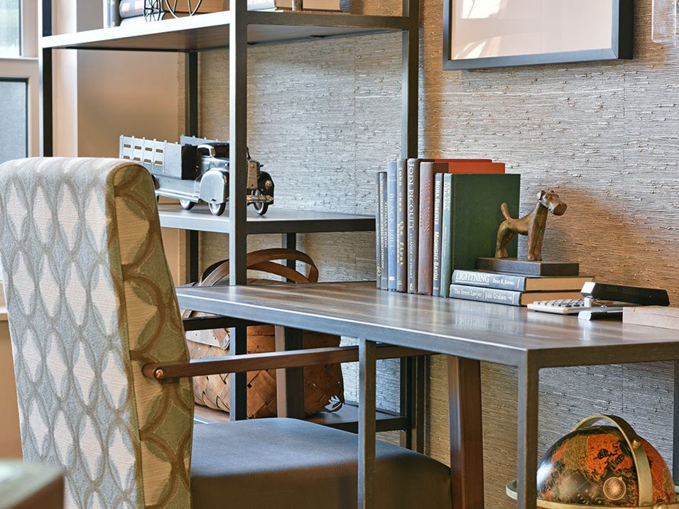 Modern office space with a wooden desk, books, a globe, and a patterned chair