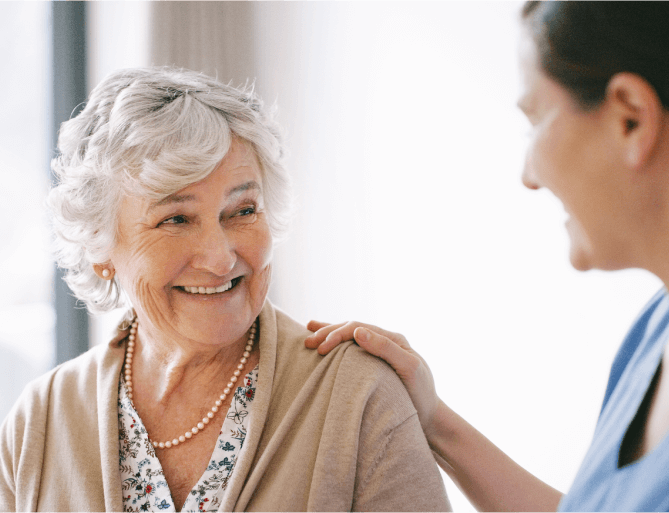 senior woman smiling at her caretaker