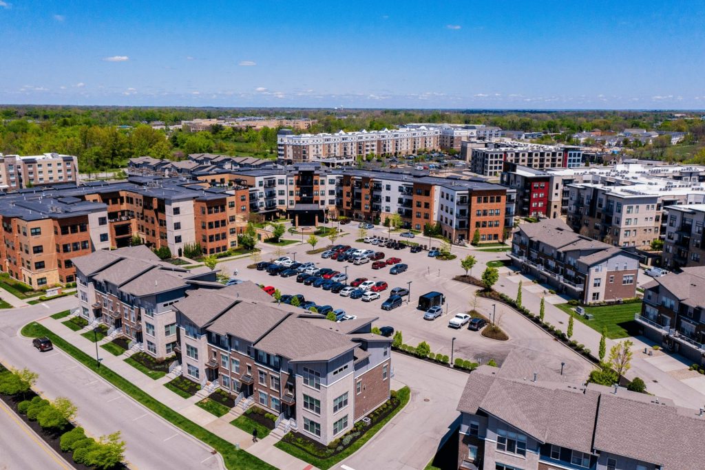 Aerial view of a suburban apartment complex with numerous buildings and parked cars