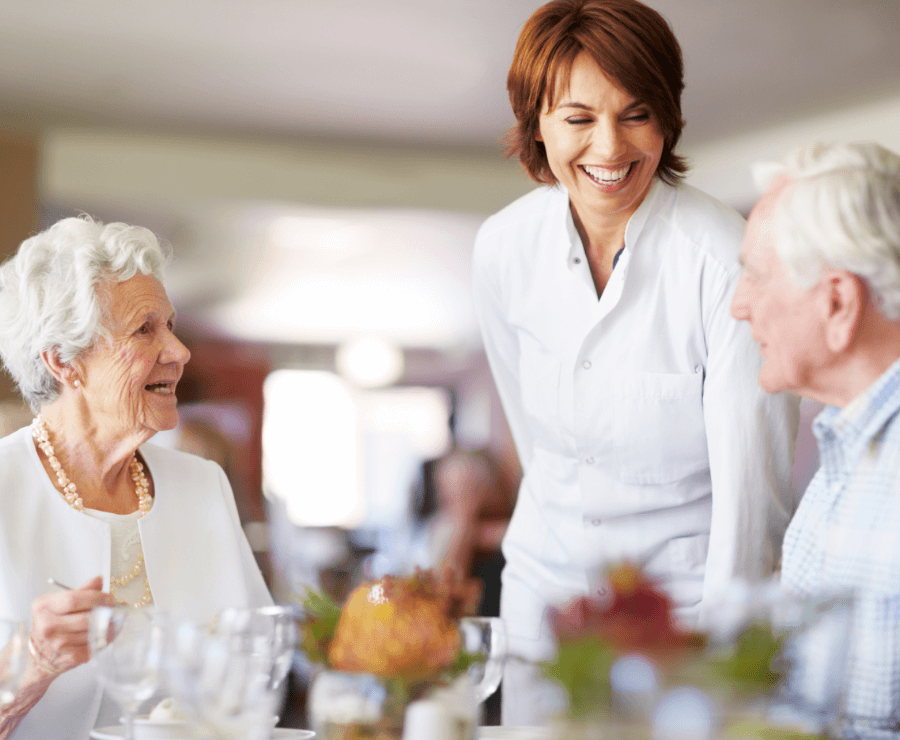 employee serving dinner to senior couple