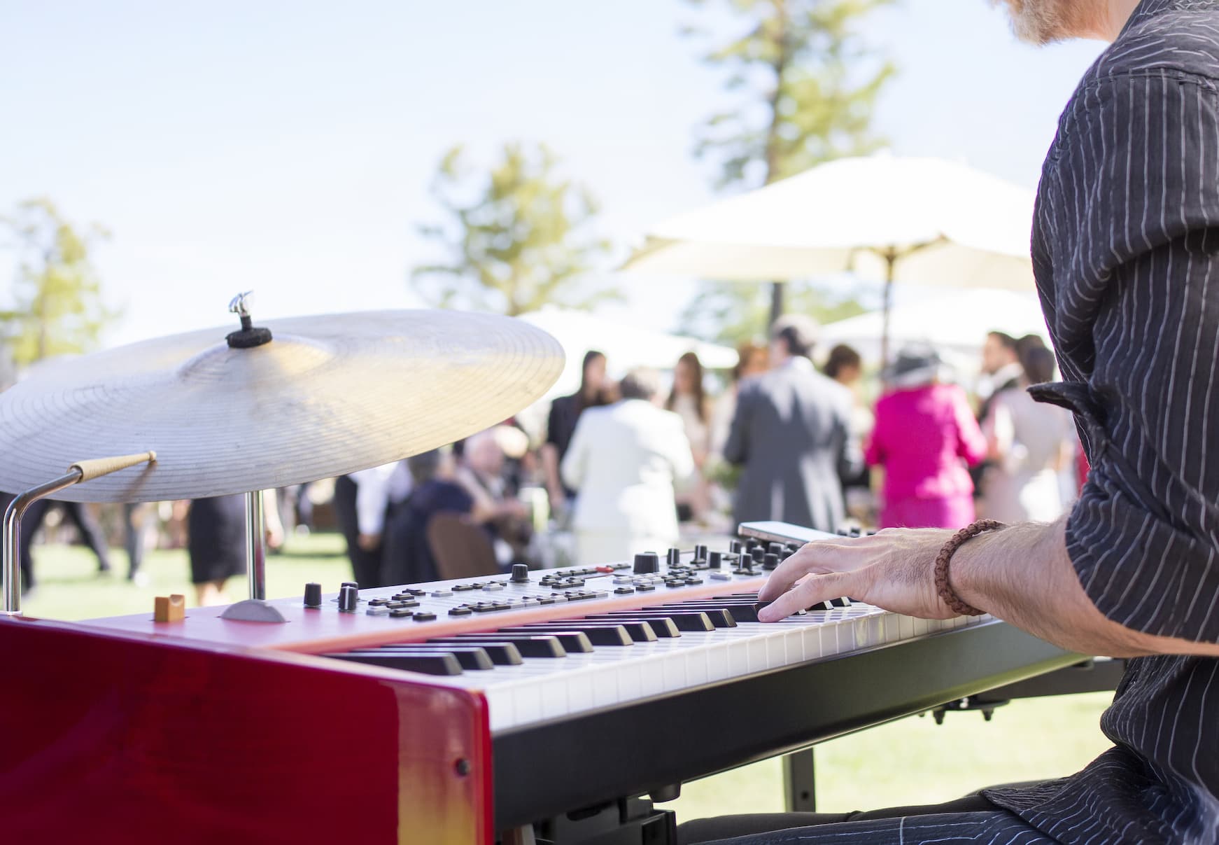 Close up of man playing a keyboard piano outdoors at a party